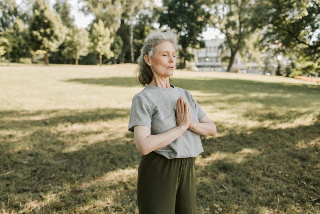 senior woman in namaste yoga position